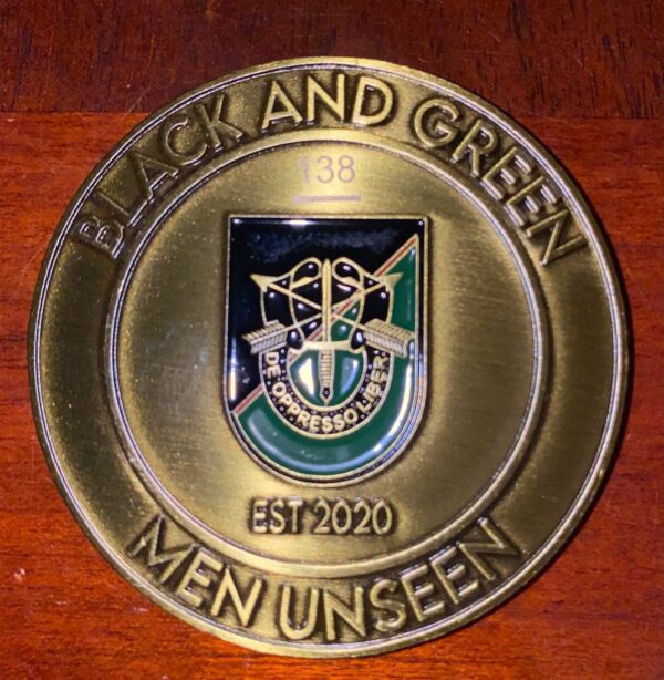 A close up of the black and green men unseen logo.