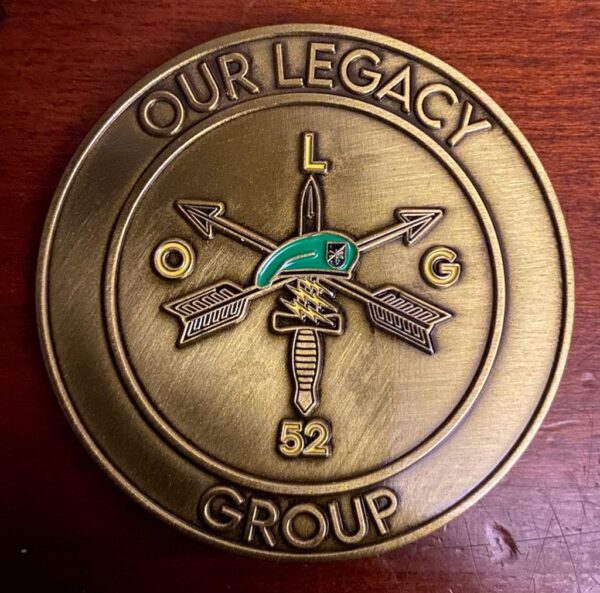 A bronze medallion with arrows and the words " our legacy group ".