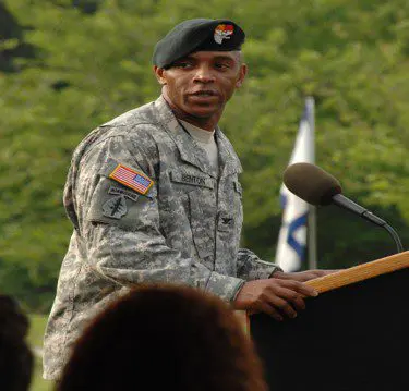 A man in military uniform standing at a podium.