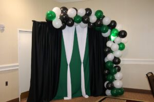A photo of a green and white balloon arch.