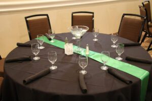 A table set with black cloth and green ribbon.