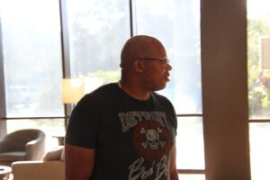 A bald man wearing glasses and a black shirt.