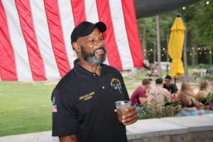 A man holding a beer in front of an american flag in color