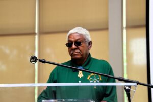 A man in a green shirt standing at a podium.