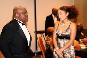 A man talking to a woman at a formal event in color